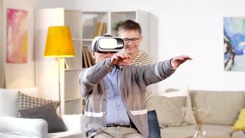 Boy Helping Senior Man Experience Virtual Reality