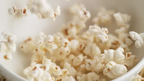 Tossing popcorn into a bowl. Slow Motion.