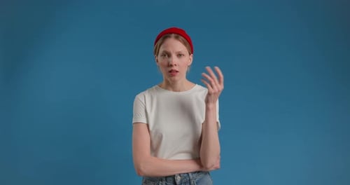 Young Woman Thinking in Front of Blue Background