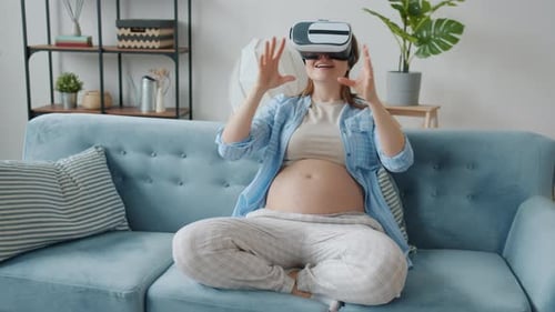 Pregnant Woman on Sofa Using Virtual Reality Headset