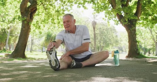 Senior man stretching his legs in the park