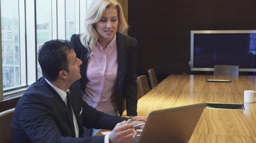 Business Professionals Discussing Project on Laptop in Office