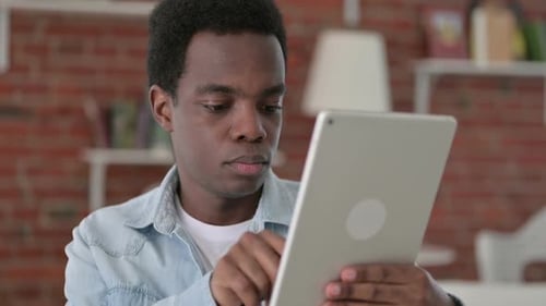 Ehrgeiziger afrikanischer Mann mit Tablet