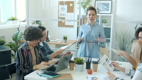 Joyful Asian Woman Talking To Group of Office Workers and Doing Highfive Enjoying Success in