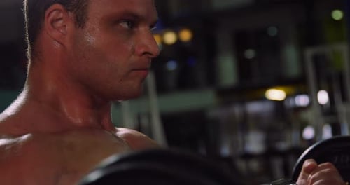 Muscular man exercising with barbell