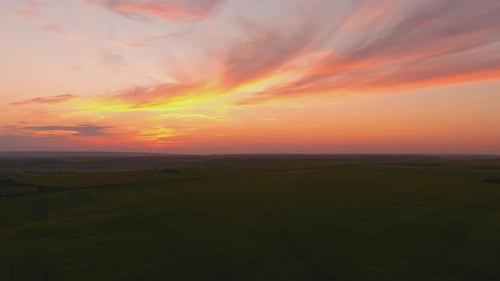 Aerial View of Tranquil Field During Colorful Sunset
