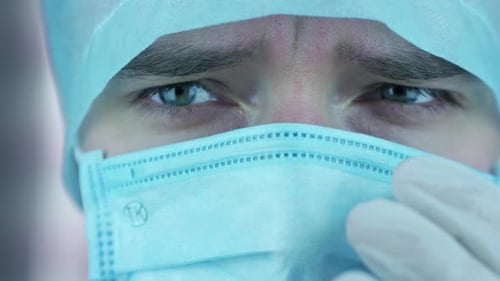 Close Up of Surgeon Adjusting Mask in Hospital