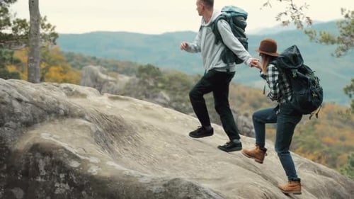 Homem ajuda amigo a subir