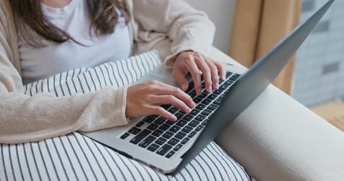 Woman Typing on Laptop at Home