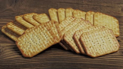 Stack of Crispy Crackers on Dark Wooden Surface