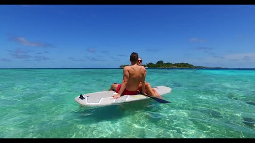 Man and lady tan on marine coastline beach break by clear ocean and white sand background of the Mal