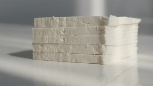 Stacked pieces of cow milk cheese 4K tilting video