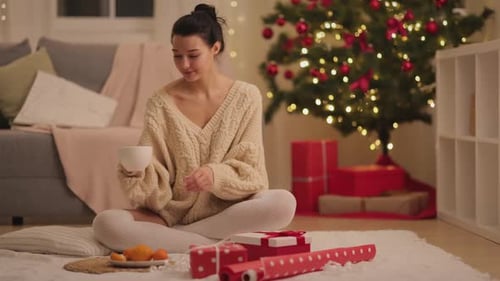 Woman Enjoys Christmas Gifts and Warm Drink