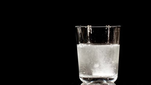 Effervescent Tablet Dissolving in Glass of Water