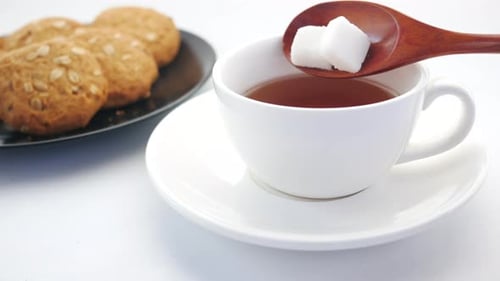 Cup of Tea and Sugar Cube on Table