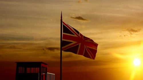 Union Jack Flag Waving Over Soldier Silhouette at Sunset