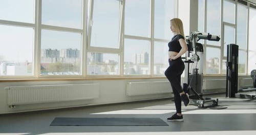 Young Active Athletic Blonde Girl Works Out in the Gym