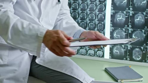 Male Doctor Filling Medical History