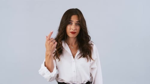Brunette Girl in White Shirt is Twisting a Finger About a Temple or Giving a Screwloose Sign While