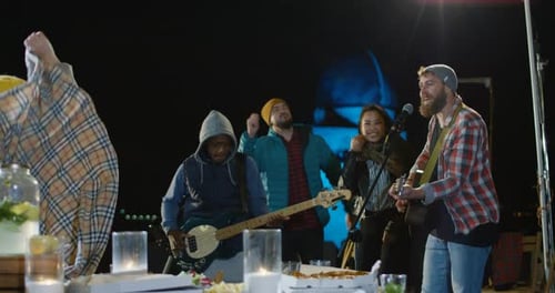 Band plays music at outdoor party at night