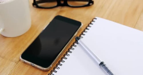 Workspace With Coffee, Phone, Notebook, and Glasses