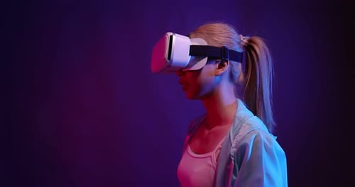 Young Asian woman playing metaverse virtual reality digital technology game with VR goggle.