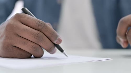 Close Up Young African Man Hand Writing Document