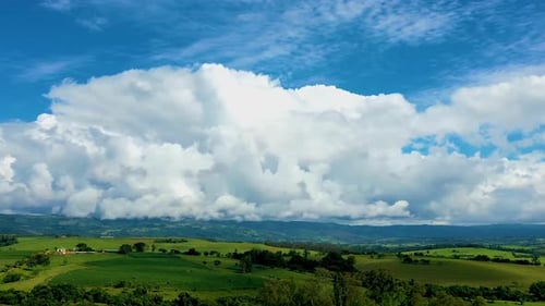 Rolling Green Hills Under Blue Sky With Clouds