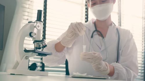 Nahaufnahme eines asiatischen Arztes, der einen Antigen-Schnelltest verwendet, der einen schnellen Abstrich für Patienten während Covid19 durchführt.