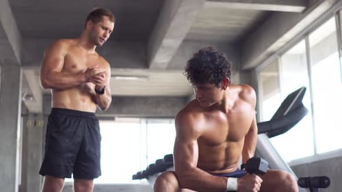 Muscular Men Training With Dumbbell In Gym