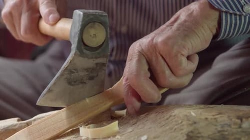 Senior Adult Carving Wood with Axe