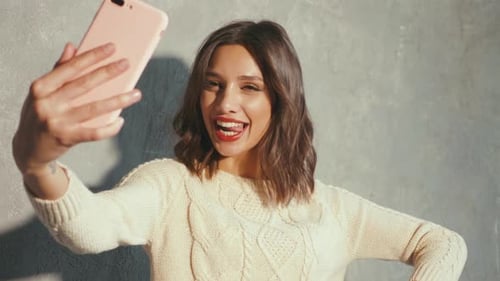 Smiling Woman Taking Selfie with Phone Indoors