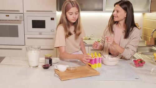 Mom And Daughter Finishing Cooking Ice-Cream