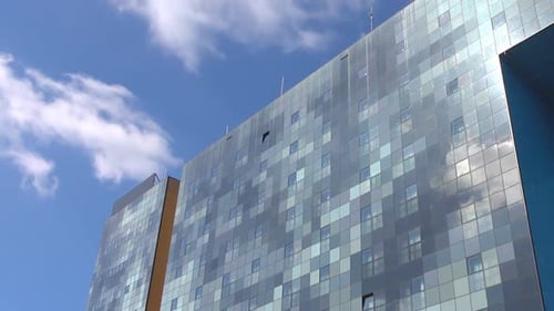 Modern Glass Skyscraper with Open Section Under Blue Sky