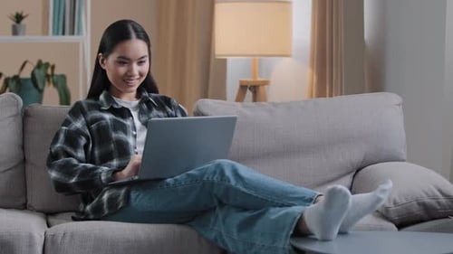 Woman Relaxing on Couch with Laptop at Home
