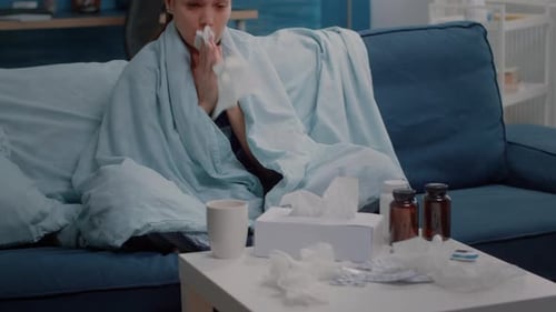 Adult Woman Sick with Cold Sits On Couch