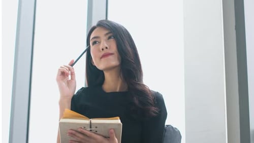 attractive asian woman black dress working and note on paper sit on sofa