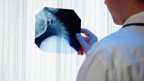 Doctor Reviews Neck X-Ray in Clinical Setting