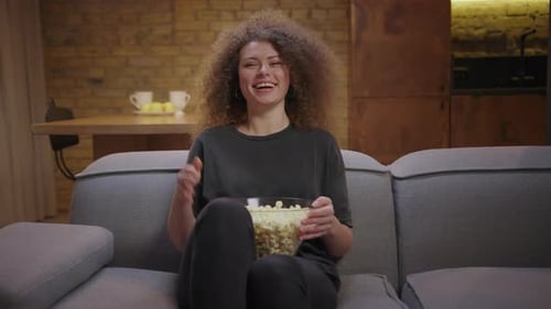 Woman with Popcorn Watching TV at Home