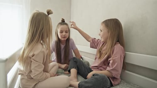 Three Children Playing a Game on a Bed