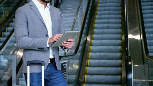 Man Using Tablet Near Escalators