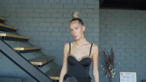 Glamorous Woman Posing in Front of Brick Wall