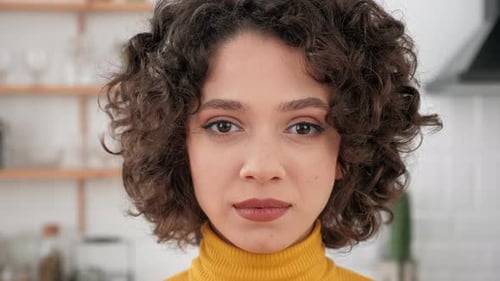 Close Up Face Hispanic Curly Woman Looking Camera Standing at Home Kitchen