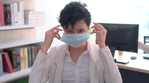 Portrait of business woman wear hygiene mask in the office with day light and bright on background