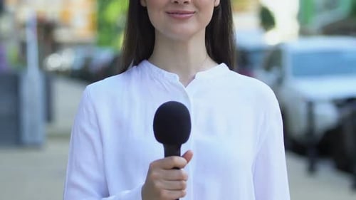 Korrespondentin hält Mikrofon im Freien, Interviewfragen, Meinung