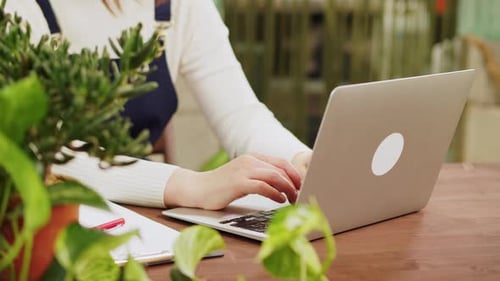 Woman Typing on Silver Laptop in Office