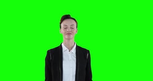 Caucasian woman raising hands on green background