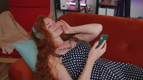 Woman Relaxing on Couch Listening to Music