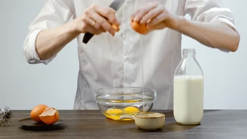 Person Cracking Eggs in Bowl for Cooking