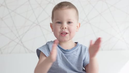 Smiling Child Clapping His Hands
